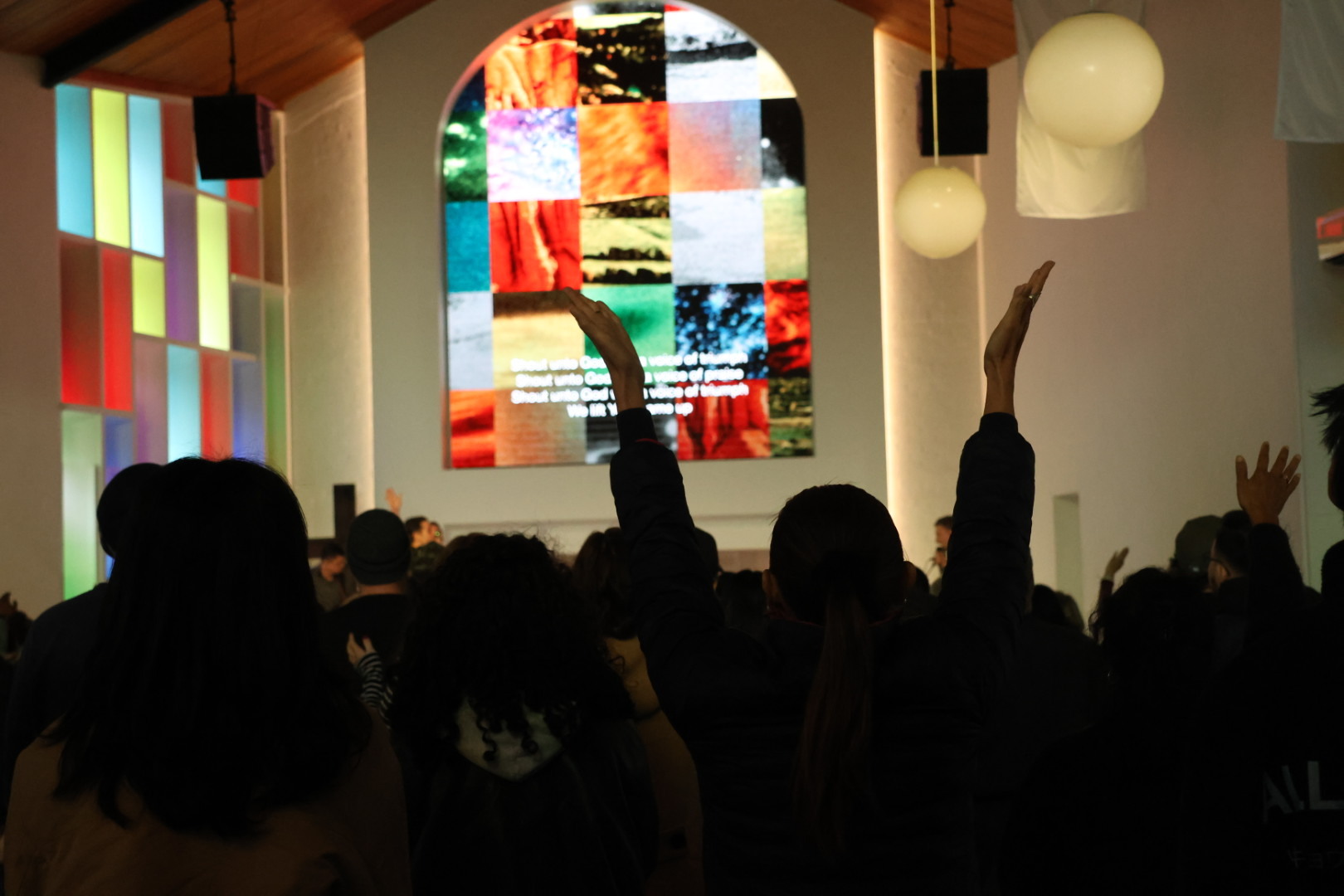 The Saints congregation raising their hands in worship